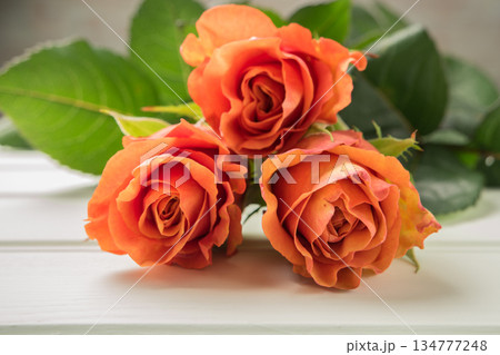 A bouquet of orange roses on wooden table. Copy space A bouquet of orange roses on wooden table. Copy space 134777248