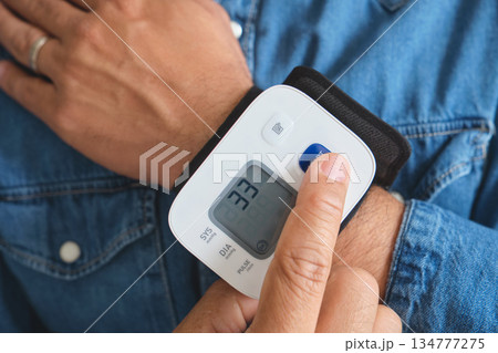 Person measuring wrist blood pressure at home 134777275