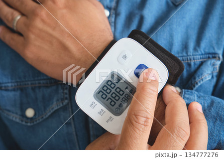 Person measuring wrist blood pressure at home 134777276