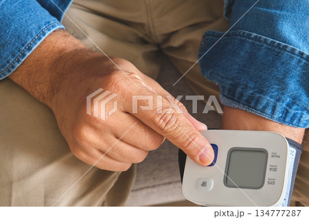 Person measuring own blood pressure for health monitoring Person measuring own blood pressure for health monitoring 134777287