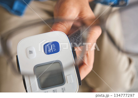 Person checking blood pressure using home monitor 134777297