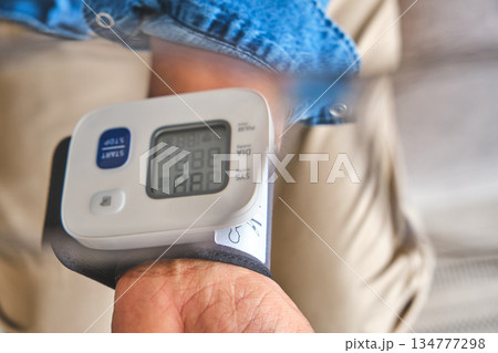 Person checking blood pressure for cardiovascular health monitoring 134777298