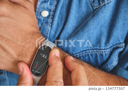 Man checking heart rate on fitness tracker smartwatch Man checking heart rate on fitness tracker smartwatch 134777307