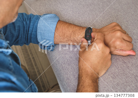 Man tracking heart rate on fitness tracker smartwatch 134777308