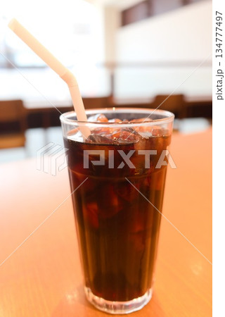 喫茶店のテーブルに置かれたアイスコーヒーのグラス 134777497
