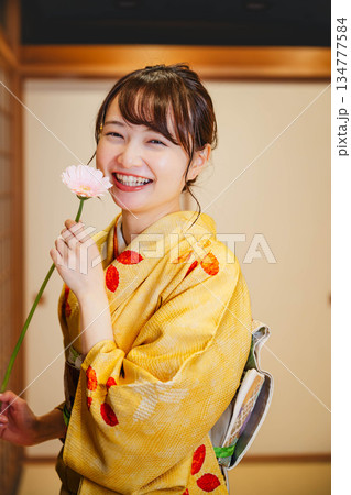 和室で花を持つ若く美しい着物女性 和室で花を持つ若く美しい着物女性 134777584