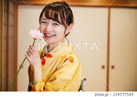 和室で花を持つ若く美しい着物女性 和室で花を持つ若く美しい着物女性 134777585