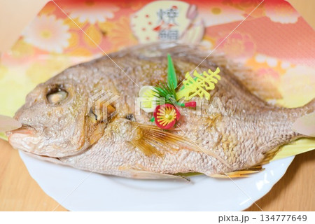 お食い初め膳に並ぶ祝い鯛の姿焼きを捉えた和食写真 134777649