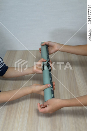 巻物を手渡す子供たちの手元の縦構図 134777714