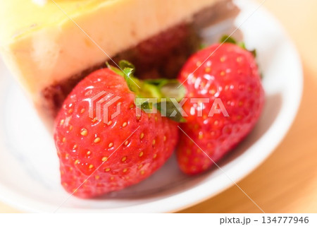 ケーキのトッピングとして輝く新鮮で赤い苺のクローズアップ 134777946