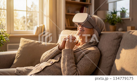 VRゴーグルを装着して仮想現実を楽しむ笑顔のシニア女性 134779175