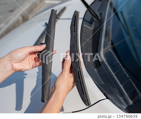 Close up of female hands changing windshield wipers.  134780639