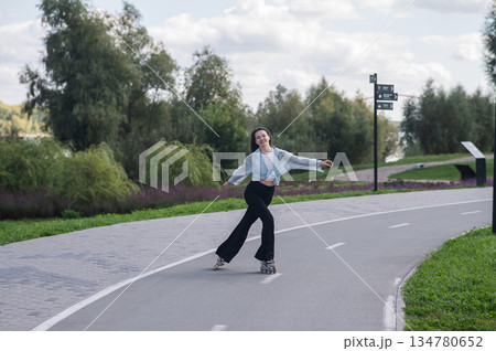 Caucasian woman roller skating in park.  134780652