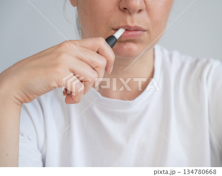 Woman smoking tobacco heating system. Electronic cigarette. Woman smoking tobacco heating system. Electronic cigarette. 134780668