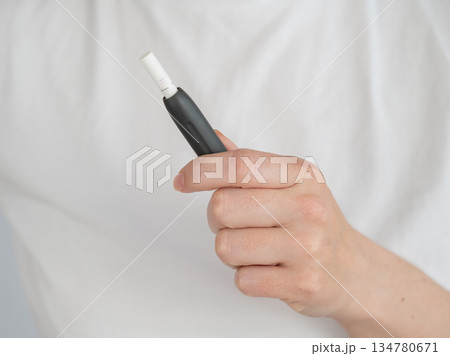 Faceless woman holding tobacco heating system.  134780671