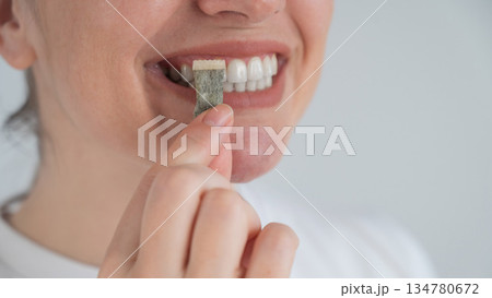 Woman Chewing Nicotine Snus Product.  134780672