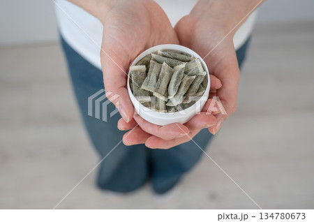 A woman holds a jar of chewing tobacco.  134780673
