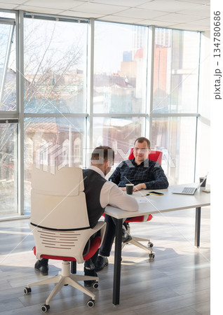 Two Caucasian men negotiating in an office. Two Caucasian men negotiating in an office. 134780686
