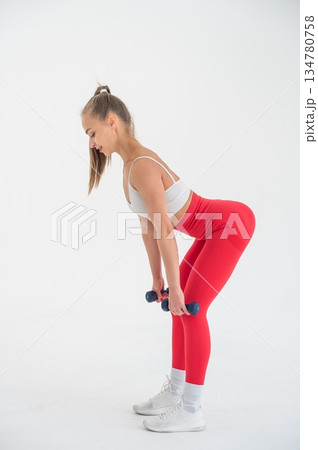 Young woman doing exercise with dumbbells on white background. Young woman doing exercise with dumbbells on white background. 134780758
