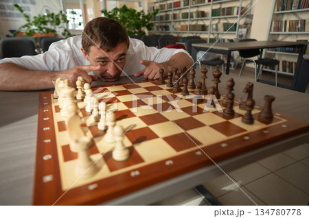Middle aged Caucasian man playing chess. Middle aged Caucasian man playing chess. 134780778