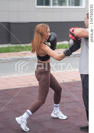 Man and woman sparring outdoors. Boxing lesson. Man and woman sparring outdoors. Boxing lesson. 134780830