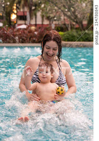 Caucasian woman holds her son while swimming in a pool on vacation. Mom teaches little boy to swim. Caucasian woman holds her son while swimming in a pool on vacation. Mom teaches little boy to swim. 134780843