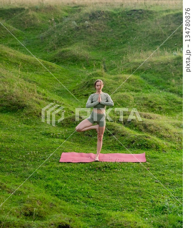 Caucasian woman doing yoga outdoors. Tree pose.  134780876