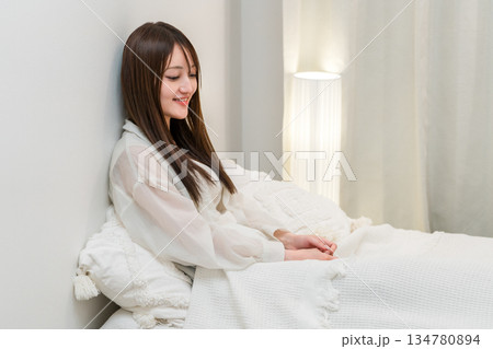 夜ベッドに入りくつろぐ若い夜ベッドに入りくつろぐ若いアジア人女性アジア人女性 134780894