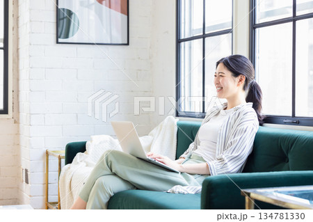 リビングでパソコンを使う若い女性 リビングでパソコンを使う若い女性 134781330