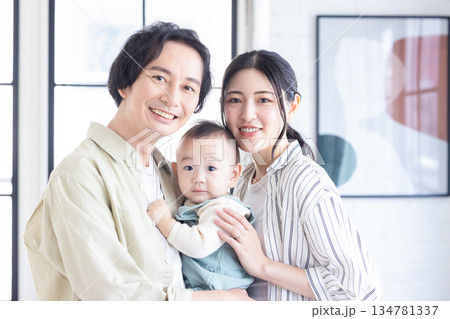 笑顔の赤ちゃんを抱っこする夫婦 134781337