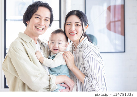 笑顔の赤ちゃんを抱っこする夫婦 134781338