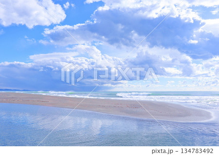 青空と雲が広がる昼のラグーンと海　静かな砂浜の風景 134783492