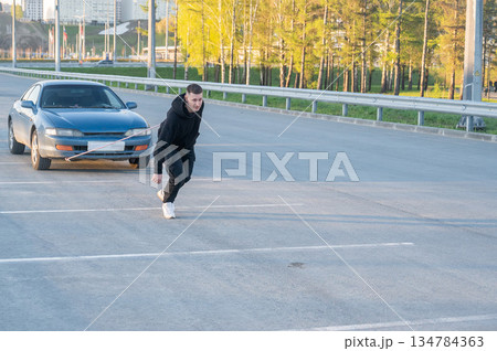 Caucasian man pulling a car with a rope.  134784363