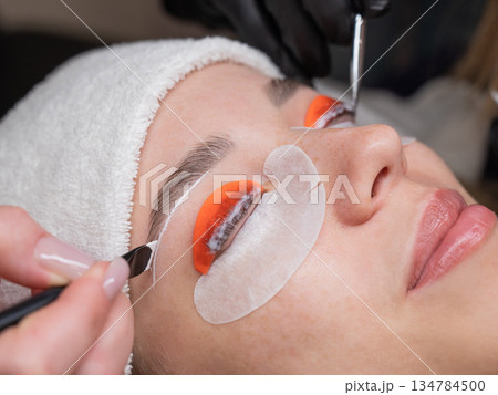 The process of professional lamination and dyeing of eyelashes and eyebrows in the salon. Four-handed procedure. The process of professional lamination and dyeing of eyelashes and eyebrows in the salon. Four-handed procedure. 134784500