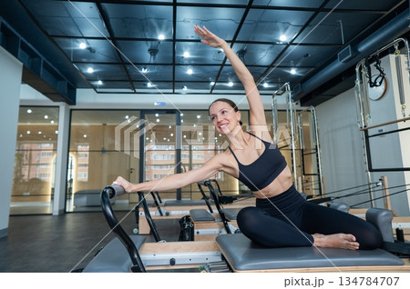 Caucasian woman doing side bends on reformer...の写真素材 [134784707] - PIXTA