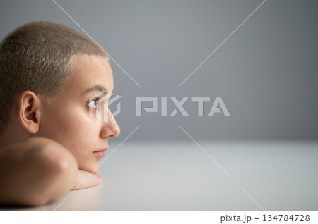 A Caucasian woman with short hair peeks out from under a table. A Caucasian woman with short hair peeks out from under a table. 134784728
