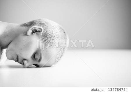 Sad woman sitting with her head on the table on a white background. Sad woman sitting with her head on the table on a white background. 134784734