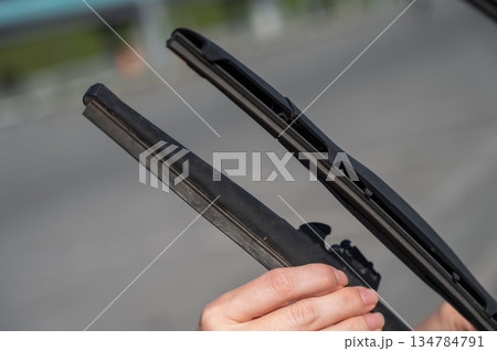 Close up of female hands changing windshield wipers.  134784791