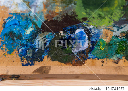 Colorful Paint Palette on Wooden Studio Palette with Blues, Greens, and Browns 134785671