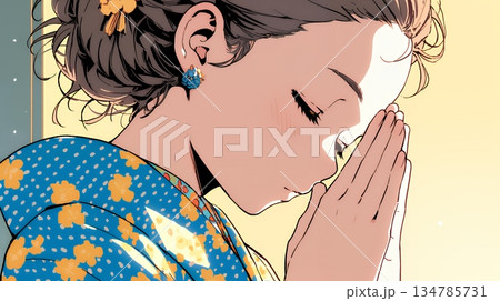 手を合わせてお祈りをしている和服姿の若い女性