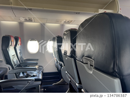 Empty airplane cabin interior with rows of passenger seats 134786387