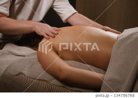 A relaxing massage session in a calm spa setting, aimed at relieving tension and improving well-being in the massage room 134786768
