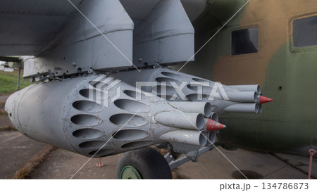 close-up rocket pod launcher with missiles and clustered tubes, weathered paint and red protective caps, 134786873