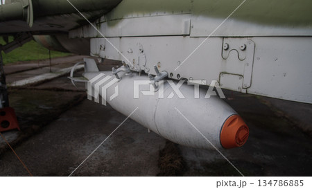 close-up external fuel tank attached to pylon with orange protective cap, attachment brackets and weathered 134786885