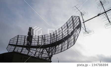 curved radar panel silhouette scanning horizon, ground surveillance and detection mood with large reflector 134786894