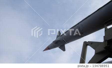 close-up helicopter missile mounted on pylon pointing skyward, fin detail and painted tip, mounting hardware close-up helicopter missile mounted on pylon pointing skyward, fin detail and painted tip, mounting hardware 134786951