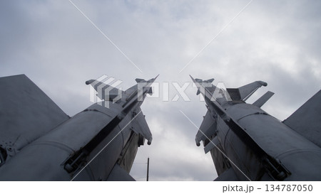 low-angle missile pair under cloudy sky, museum display emitting ominous cold war tension; metal surfaces, low-angle missile pair under cloudy sky, museum display emitting ominous cold war tension; metal surfaces, 134787050