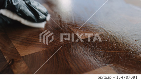 woodworker applying oil finish to walnut end grain wood board 134787091