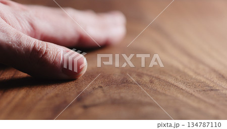man hand touch oil finished black walnut wood surface 134787110