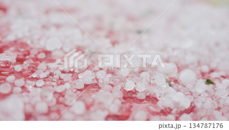 closeup of hailstones on red car after strong hailstorm 134787176